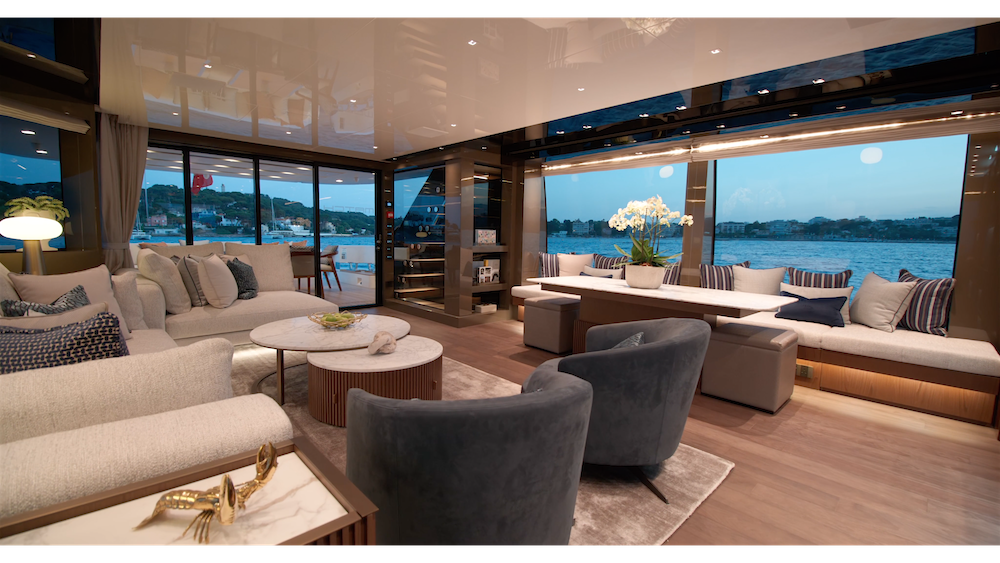 Interior of a motor yacht with floor to ceiling windows and wooden floors