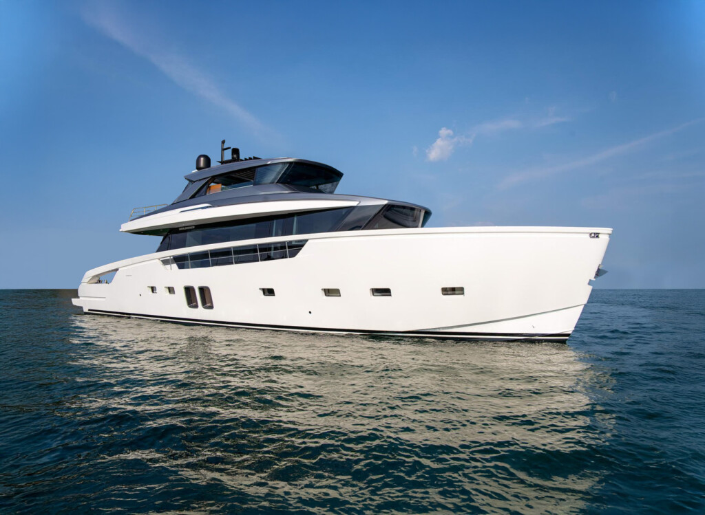 Starboard side view of a motor yacht with a white hull and grey flybridge